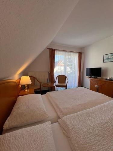 a hotel room with two beds and a window at Pension Störtebeker in Prerow