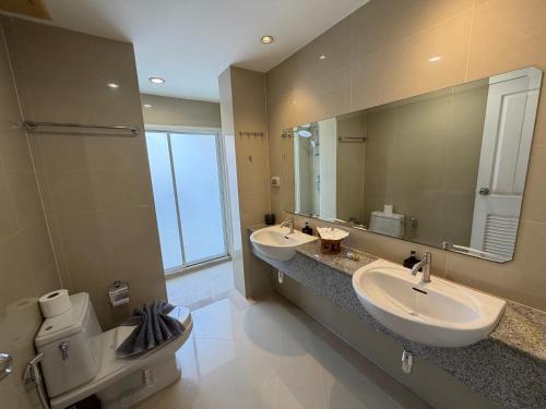 a bathroom with two sinks and a large mirror at Kata Kata Stay in Kata Beach
