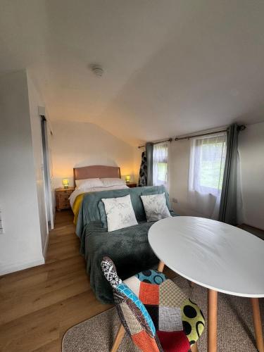 a room with a couch and a table and a bed at The Orchard Cabin in Cardington