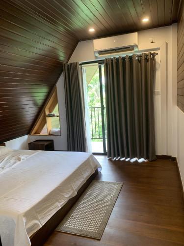 a bedroom with a bed and a large window at Centri Villa in Anuradhapura