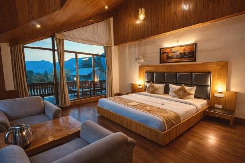 a bedroom with a large bed and a balcony at Amarys Boutique Stays Manali in Manāli