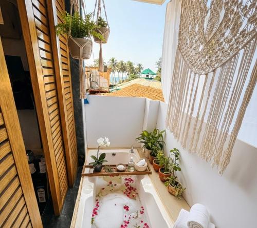 a bathroom with a bath tub with plants in it at EKAM in Agonda