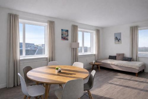 a living room with a table and chairs and a bed at PAK Central apartment Odense C in Odense