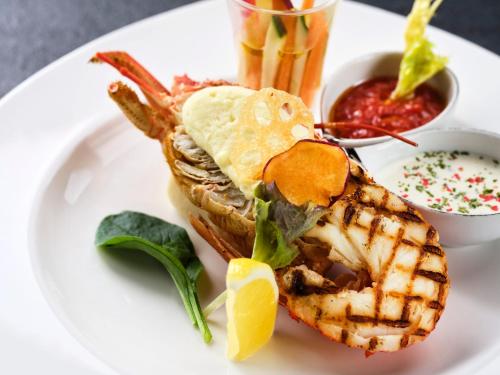 a white plate with a grilled shrimp and a waffleaffle at KAMENOI HOTEL Itako in Itako