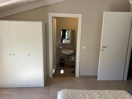 a bathroom with white cabinets and a sink at Il colle in Lucca