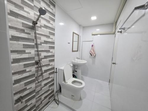 a bathroom with a toilet and a glass shower at Huggdaily 7 in Ban Khlong Thewa