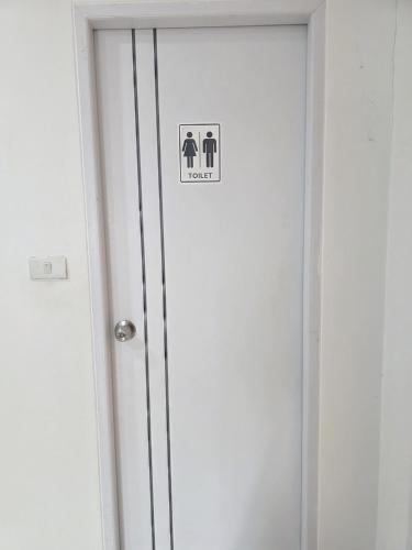 a bathroom door with a sign on it at Huggdaily 7 in Ban Khlong Thewa