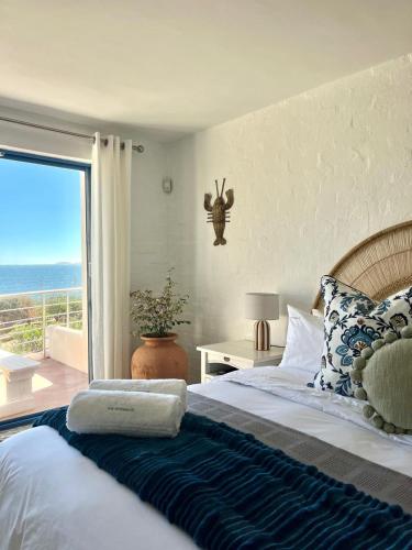 a bedroom with a bed with a view of the ocean at Endless blue ocean view escape in Langebaan