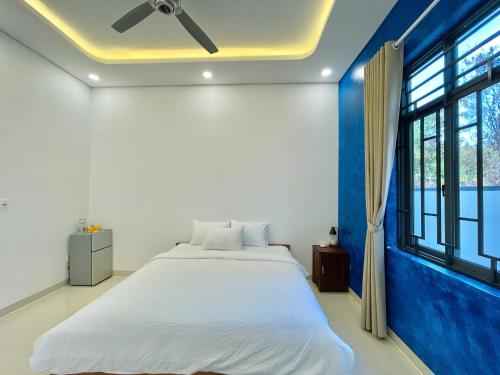 a bedroom with a large bed and a window at KIMO HOUSE Khem Beach in Phú Quốc