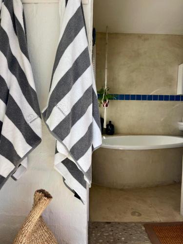 a bathroom with a bath tub and a shower curtain at Endless blue ocean view escape in Langebaan