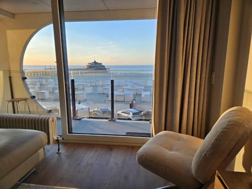 a room with a large window with a view of the ocean at Isola Bella - Luxe Verblijf op de Zeedijk met Panoramisch Uitzicht in Blankenberge