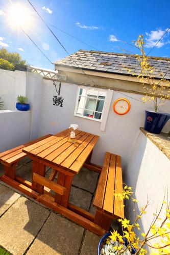 a picnic table and bench in front of a house at Charming 2 bedroom cottage in Brecon - families and pets welcome! in Brecon