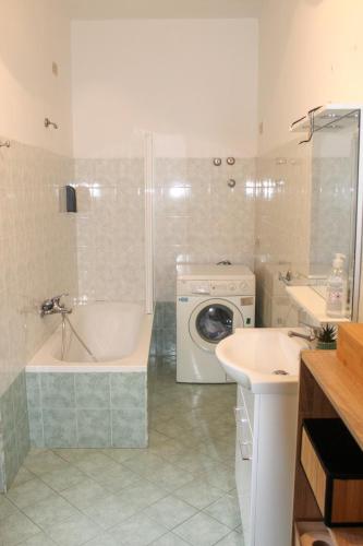 a bathroom with a tub and a washing machine at SudOceania Apartment in Lamezia Terme