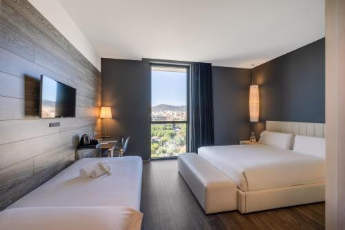 a hotel room with two beds and a tv at Hotel SB Plaza Europa in Hospitalet de Llobregat
