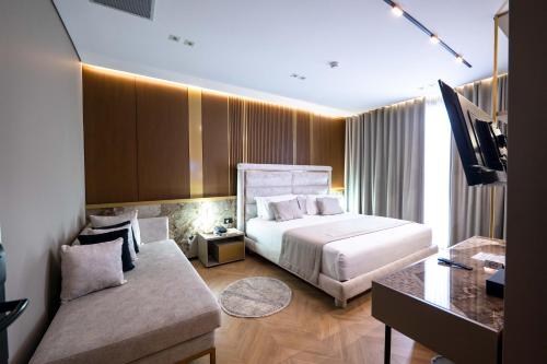 a hotel room with a bed and a couch at Duka's Boutique Hotel in Ksamil