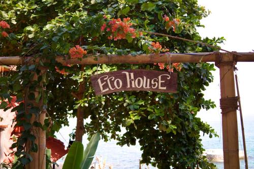 a sign that says ego house hanging from a tree at Ecohouse Hòn Sơn in Lai Sơn