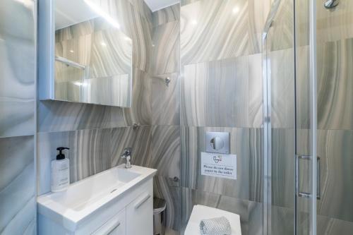 a bathroom with a sink and a shower at Thalassa & Thalassa Prive Residential Complex in Ofrínion