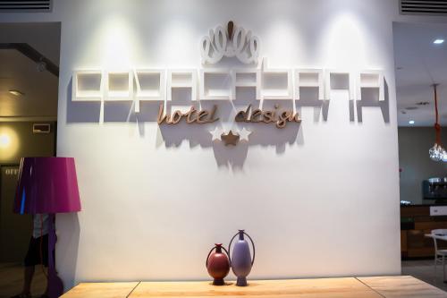 a wall with a sign for a hotel desk at Copacabana Hotel Design in Margherita di Savoia