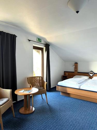 a bedroom with a bed and a table and chairs at Zum Lahnfelsen Gräveneck in Gräveneck