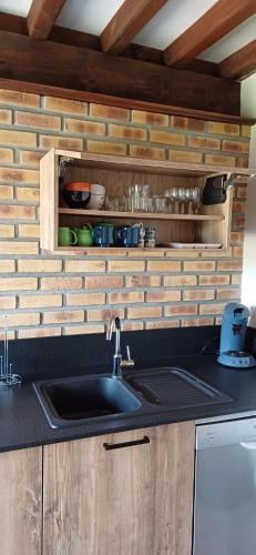 a kitchen with a sink and a wooden wall at Retour en Baie in Pendé
