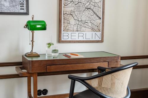 a desk with a green lamp and a chair at Numa Berlin Potsdamer Platz in Berlin