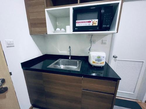 a small kitchen with a sink and a microwave at เพียร์93 in Ban Pak Khlong Si