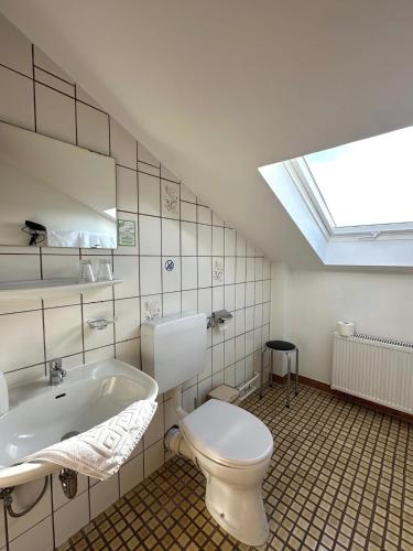 a bathroom with a toilet and a tub and a skylight at Zum Lahnfelsen Gräveneck in Gräveneck
