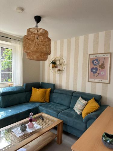 a living room with a blue couch and a coffee table at Brockmann, Ferienidylle in Neuenkirchen