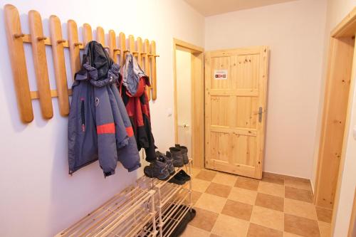 a hallway with coats and shoes hanging on a wall at Red Pine Apartments in Vlachovice