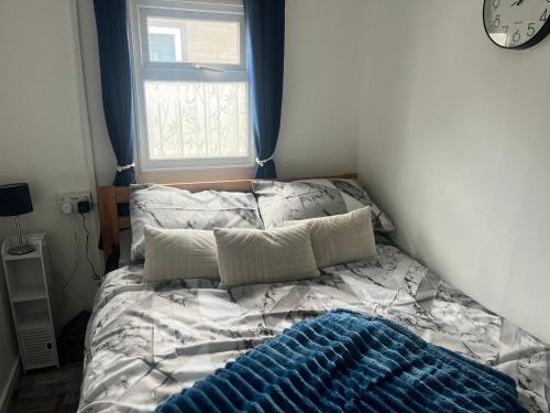 an unmade bed in a bedroom with a window at The Snug - All Seasons Chalet Breaks in Leysdown-on-Sea