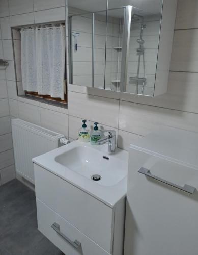 a white bathroom with a sink and a mirror at An-der-Stadtmauer in Fladungen