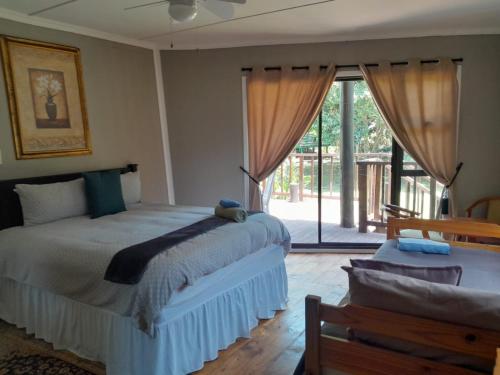 a bedroom with a bed and a sliding glass door at B Cubed Lodge in Port Shepstone