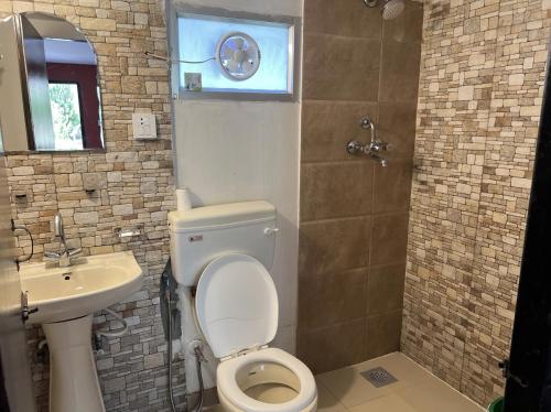 a bathroom with a toilet and a sink at Dakshinkali & Dollu Resort in Pharping