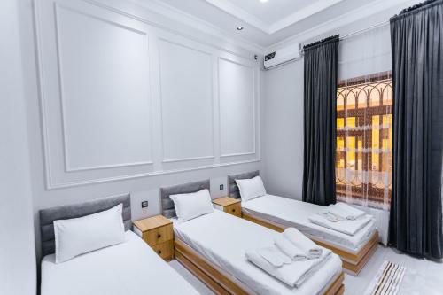 a room with two beds and a window at Classic Hotel Samarkand in Samarkand