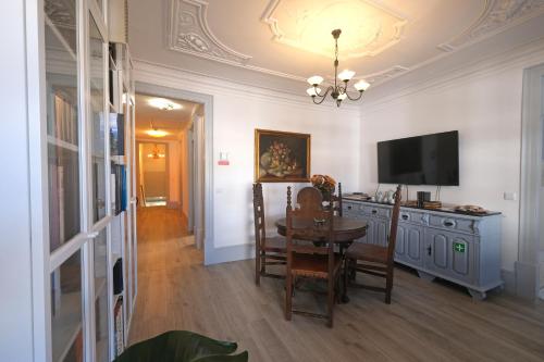 a dining room with a table and a television at Santiago de Caminha Boutique Hostel & Suites in Caminha