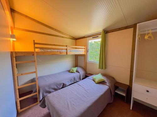 a bedroom with two bunk beds and a window at Résidence Torre Del Far in Tautavel