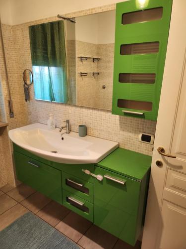 a green bathroom with a sink and a mirror at BINARIO ZERHO Luxury Apt in Rho