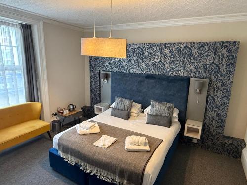 a bedroom with a large bed with towels on it at Royal Sportsman Hotel in Porthmadog