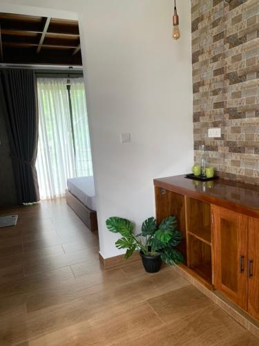 a living room with a wooden cabinet and a plant at Centri Villa in Anuradhapura