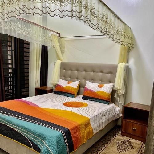 a bedroom with a bed with a canopy at KiGALI CITY COMFORT ACCOMMODATION in Kigali