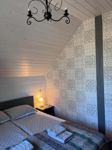 ein Schlafzimmer mit einem Bett und einem Kronleuchter in der Unterkunft Stikāni in Bernāni