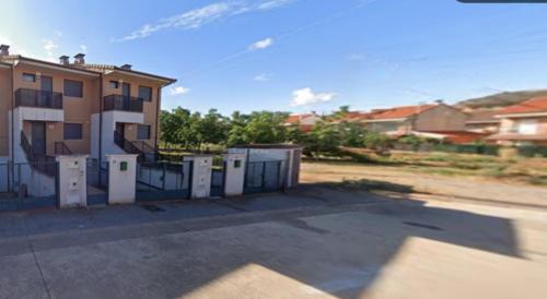 a building with a fence in front of a house at Casa Entre Viñas, jardin privado con piscina comunitaria in Uruñuela