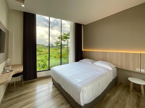 a bedroom with a large bed and a large window at Oemah Djari Hotel Syariah Salatiga in Salatiga