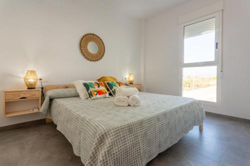 a bedroom with a bed with two towels on it at AT Ponent II B3 in Oliva