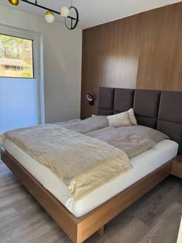 a bedroom with a large bed with a brown headboard at Lütte Lina in Neuenkirchen