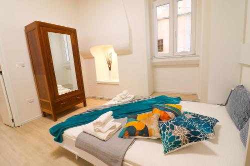 a bedroom with a bed with a mirror and a window at Penelope's House in Otranto in Otranto