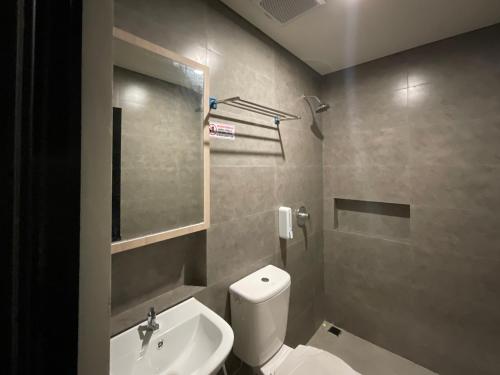 a bathroom with a white toilet and a sink at Oemah Djari Hotel Syariah Salatiga in Salatiga