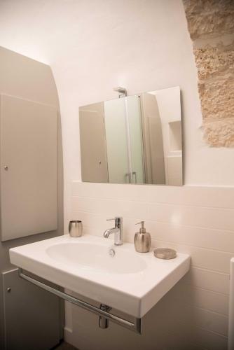 a bathroom with a white sink and a mirror at Trullo Fico d'India in Alberobello