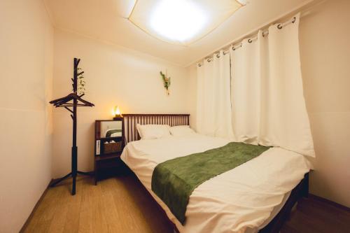 a small bedroom with a bed and a window at Cozy 2 6 Guest Stay near Gangnam 6 min from Nakseongdae Station in Samgong
