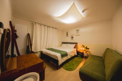 a small bedroom with a bed and a couch at Cozy 2 6 Guest Stay near Gangnam 6 min from Nakseongdae Station in Samgong
